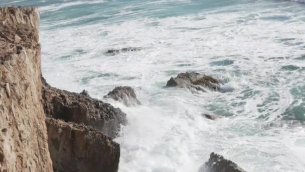 Las olas golpean las rocas. Vista desde un acantilado sobre el océano — Vídeo de stock