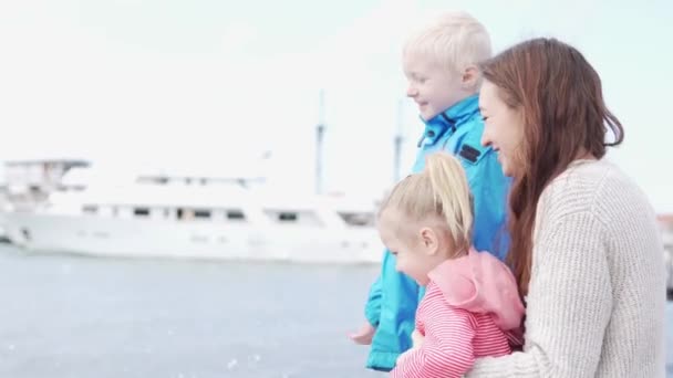 女性と彼女の子供たちは涼しい春の日に海を見ています — ストック動画