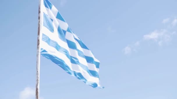 Una gran bandera de Grecia ondea en el viento contra el cielo con nubes blancas . — Vídeos de Stock