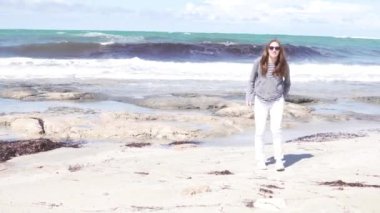 Deniz kenarında sahilde yürüyen kadın