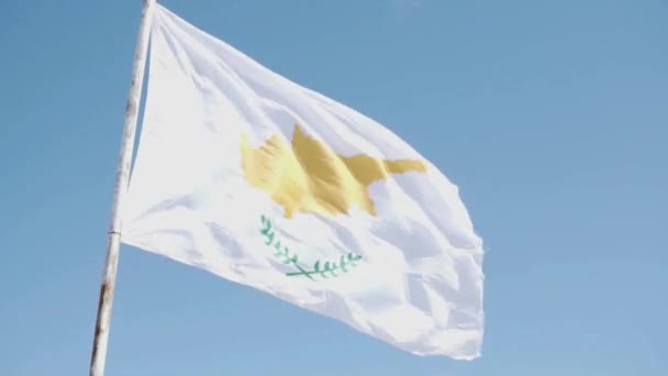 Eine große Flagge Zyperns wird vor blauem Himmel entworfen — Stockvideo