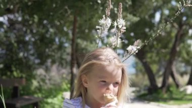 Küçük kız sarışın sıcak bir günde bir waffle fincan dondurma yiyor