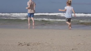 Bir erkek ve kız sahilde oynuyorlar..