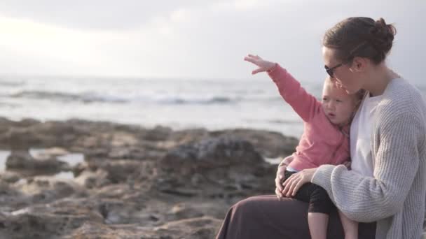 Mama cuddles i ogrzewa jej małą córkę. — Wideo stockowe