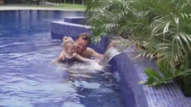 Pappa med en liten dotter simma i poolen. — Stockvideo