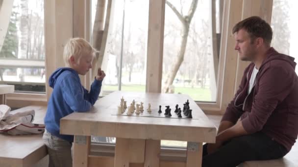 Papa mit seinem Sohn beim Schachspielen. — Stockvideo