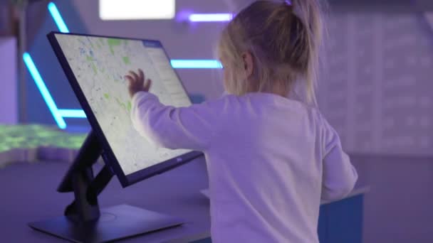 Een klein meisje kijkt naar een kaart van de groenste gebieden — Stockvideo