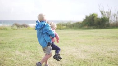 Oğlan küçük bir kızı döndürüyor..