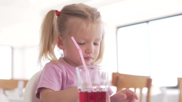 Маленькая девочка ест картошку фри с кетчупом в кафе — стоковое видео