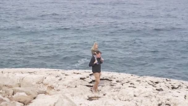 お父さんは海に沿って彼の肩に小さな娘を運ぶ — ストック動画