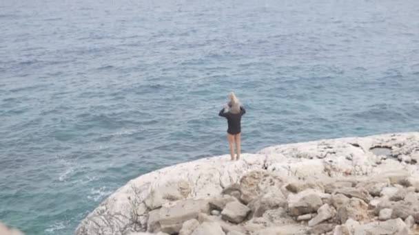 Un hombre con una pequeña hija descendió al mar en un alto acantilado — Vídeos de Stock