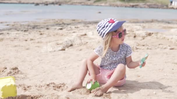 Kid playing with sand. Little girl plays on the beach — Stock Video