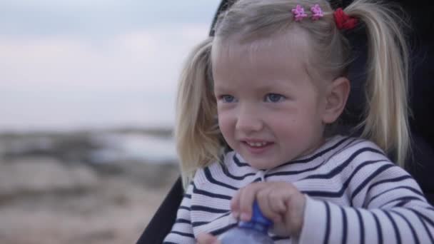 Μικρό κορίτσι πόσιμο νερό από ένα πλαστικό μπουκάλι — Αρχείο Βίντεο