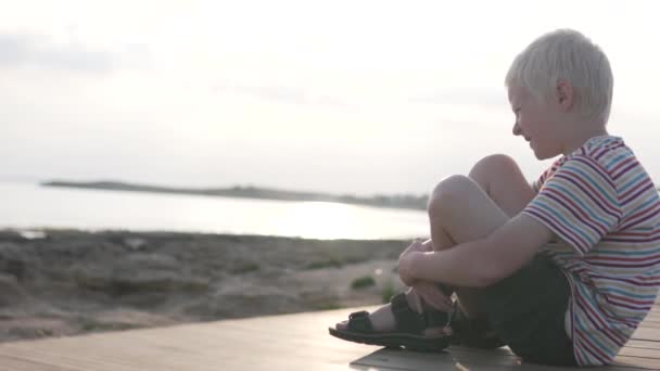 Расстроенный ребенок на прогулке в парке у моря . — стоковое видео