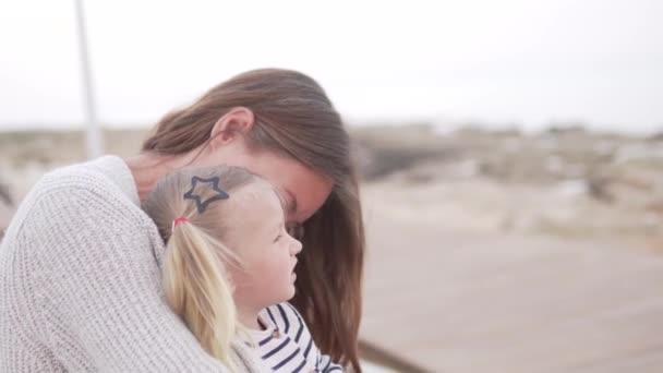 Moeder en haar kleine dochter zitten op het strand — Stockvideo