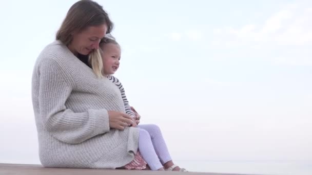 Мама обіймає маленьку дочку. Мама зігріває замороженої дитини. — стокове відео