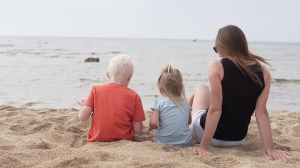 Donna con bambini seduta sulla spiaggia . — Video Stock