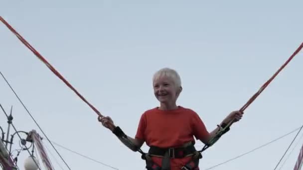 Çocuk yüksek bir trambolin üzerinde atlar — Stok video