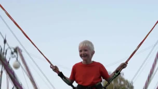 Boy blond jumps on trampoline — Stock Video