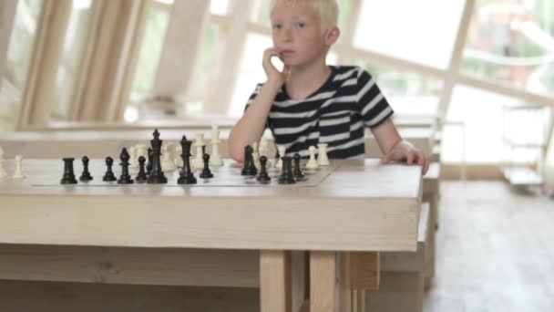 Schöner blonder Junge beim Schachspielen. — Stockvideo