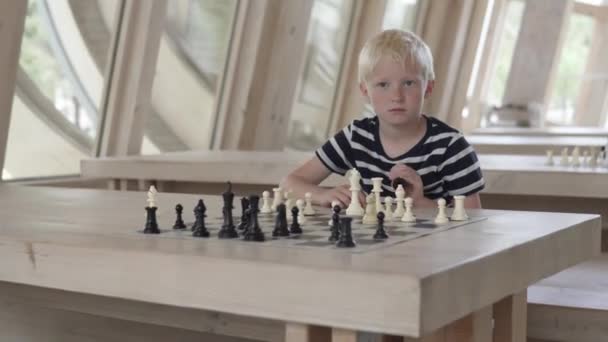 Handsome blond boy playing chess — Stock Video