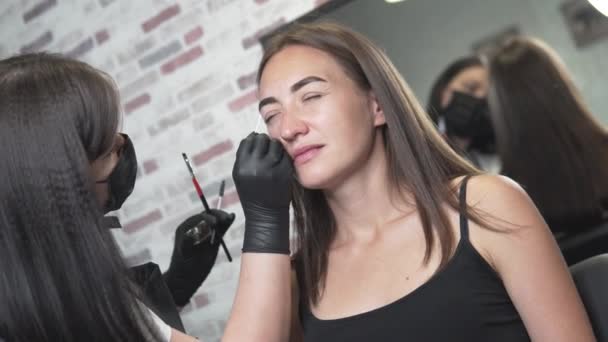 Жінка робить корекцію і забарвлення брів в салоні — стокове відео