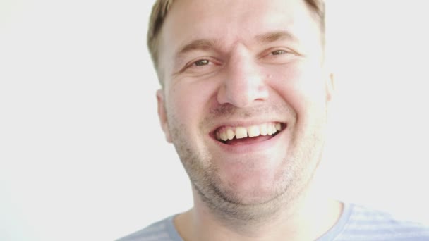 Um homem bonito ri-se. close-up de um rosto masculino alegre — Vídeo de Stock