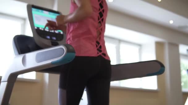有吸引力的运动女孩训练她的臀部在跑步机上 — 图库视频影像