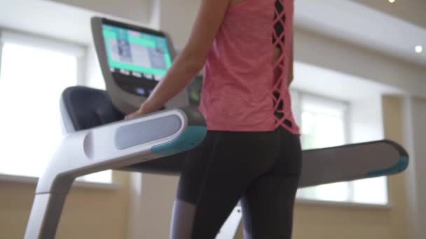 Mladá sexy žena běží na simulátoru běžecký pás v hale — Stock video