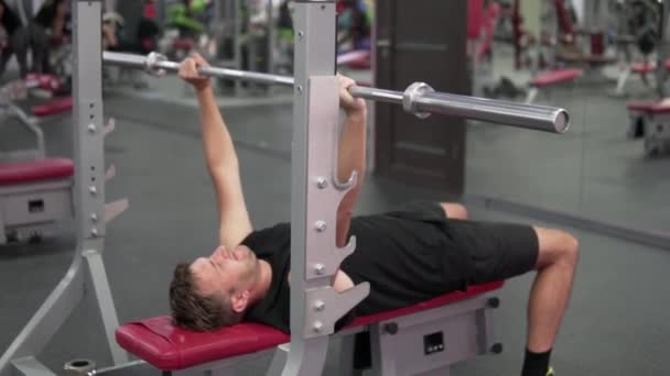 A man shakes his muscles in the gym — Stock Video