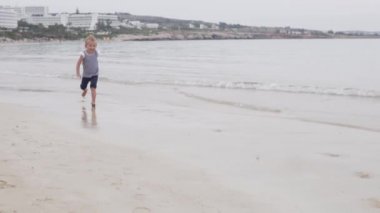 Çocuk sahil boyunca koşar..