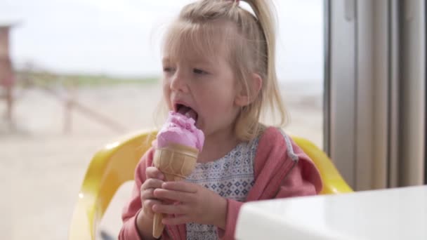 Uma menina bonita goza de um delicioso cone de sorvete durante o verão . — Vídeo de Stock