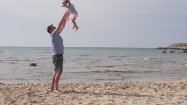 Slow motion of handsome father throwing his adorable daughter in the air — Stock Video