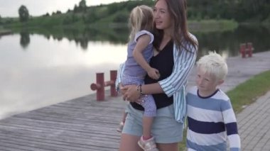 Anne ve çocuklar golf kulübünde set boyunca yürüyorlar.