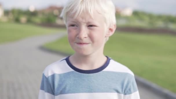 Χαριτωμένο αγόρι ξανθιά βόλτες στο πάρκο το καλοκαίρι — Αρχείο Βίντεο