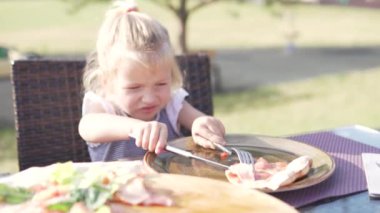 Küçük kız bir yaz kafede bir masada pizza yemek