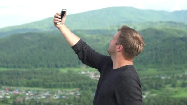 El turista es fotografiado en la cima de la montaña — Vídeos de Stock