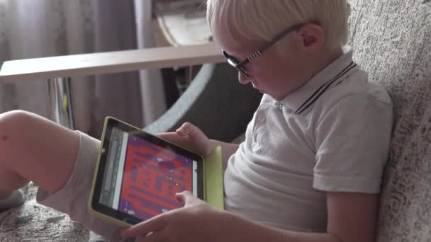 Мальчик-альбинос играет в игру на планшете — стоковое видео