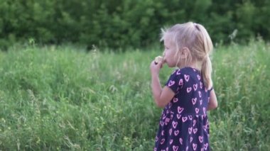 Küçük kız gün batımında parkta dondurma yiyor