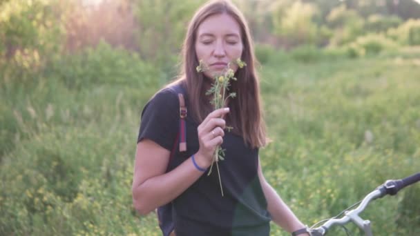 Una mujer huele flores silvestres amarillas . — Vídeos de Stock