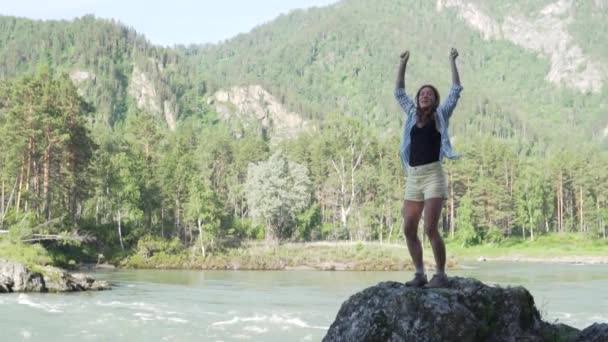 Mooie vrouw springen voor vreugde en verhoogt haar handen omhoog — Stockvideo