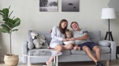 Baba, anne ve kızı sabah ları oturuyorlar.