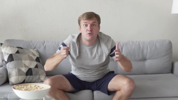 Rolig fläkt med popcorn hemma på soffan — Stockvideo