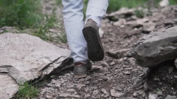 Primer plano de las piernas de la mujer senderismo terreno empinado en las montañas — Vídeo de stock