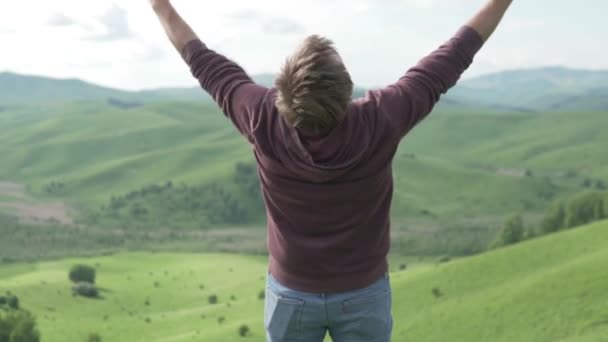 Il est venu en premier dans la campagne de randonnée. Heureux touriste lève les mains sur le fond des montagnes — Video