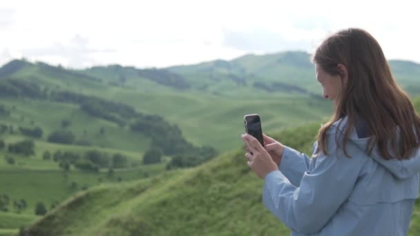 Mooie jonge vrouw in foto maken op een mobiele telefoon — Stockvideo
