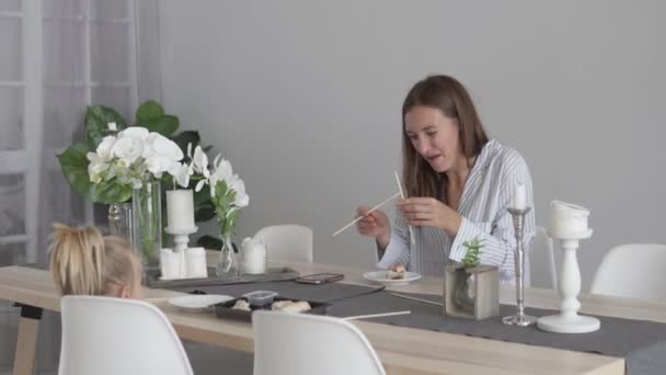 Mom and her little daughter eat ready-made sushi from a shop — Stock Video