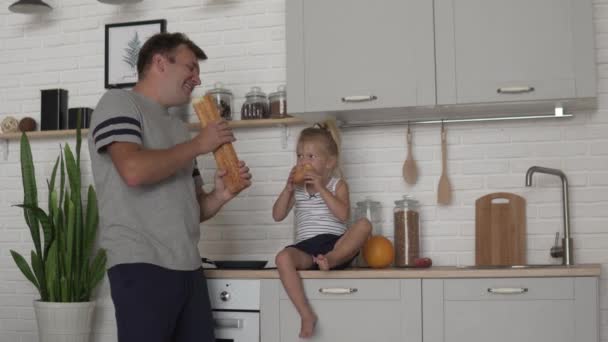 Komik baba mutfakta sabah küçük kızı ekmek besler — Stok video