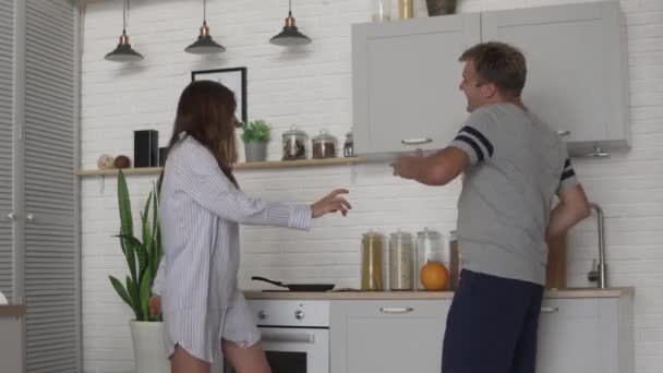 Vidám tánc az ember és a nő a konyhában a reggeli — Stock videók