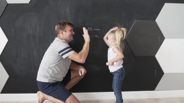 Baba ve kızı olayın başarı işareti olarak birbirlerinin avuçlarını alkışlarlar. — Stok video